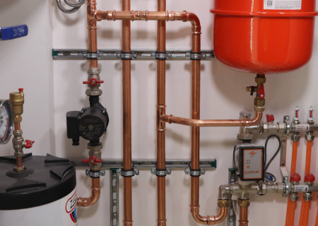 Kupferrohrinstallation im Technikraum mit Rohrschellen an Walraven RapidRail® Montageschienen, Pumpen und Ausdehnungsgefäß.