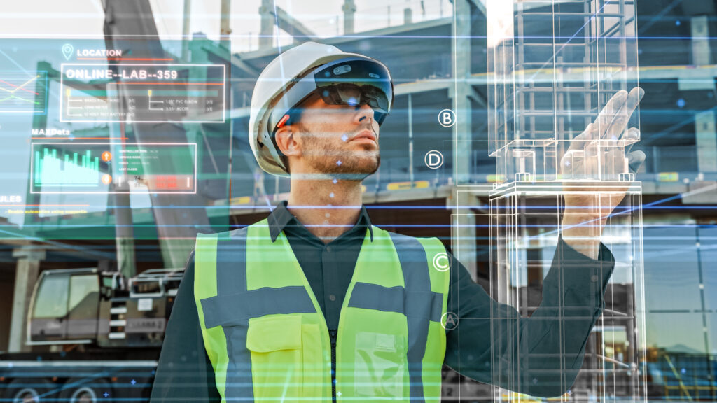 Futuristic Architectural Engineer Wearing Augmented Reality Headset, Uses Gestures to Create 3D Graphics VFX Model of a Building with Infographics. In Background Construction Site in Progress